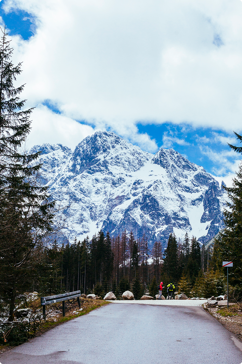 two-tourist-standing-road-near-snowy-mountain